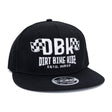 Black snapback cap front view with white DBK logo and 'DIRT BIKE KIDEZ' graphic
