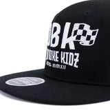 Black snapback cap close-up of white DBK logo on the crown