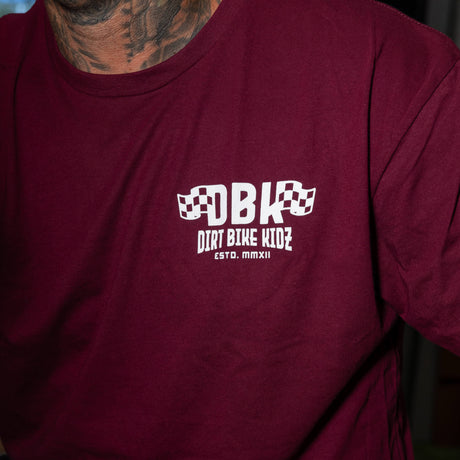 Maroon graphic T-shirt close-up of chest DBK logo with “Dirt Bike Kidz” beneath