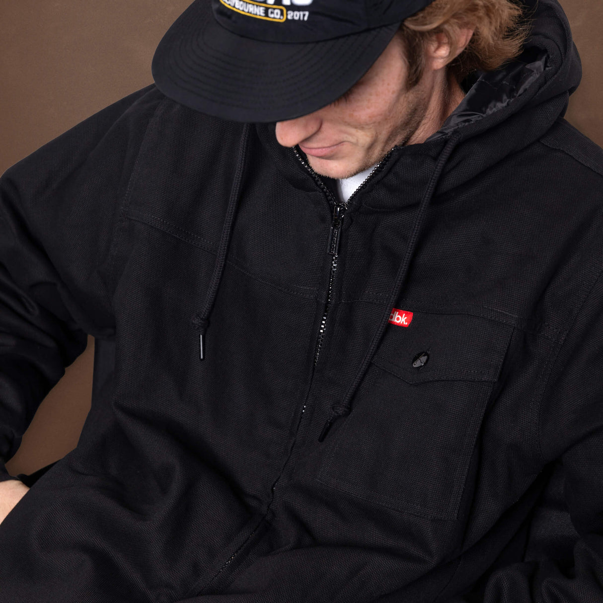 Black zip-front jacket with two chest pockets and hood drawstrings