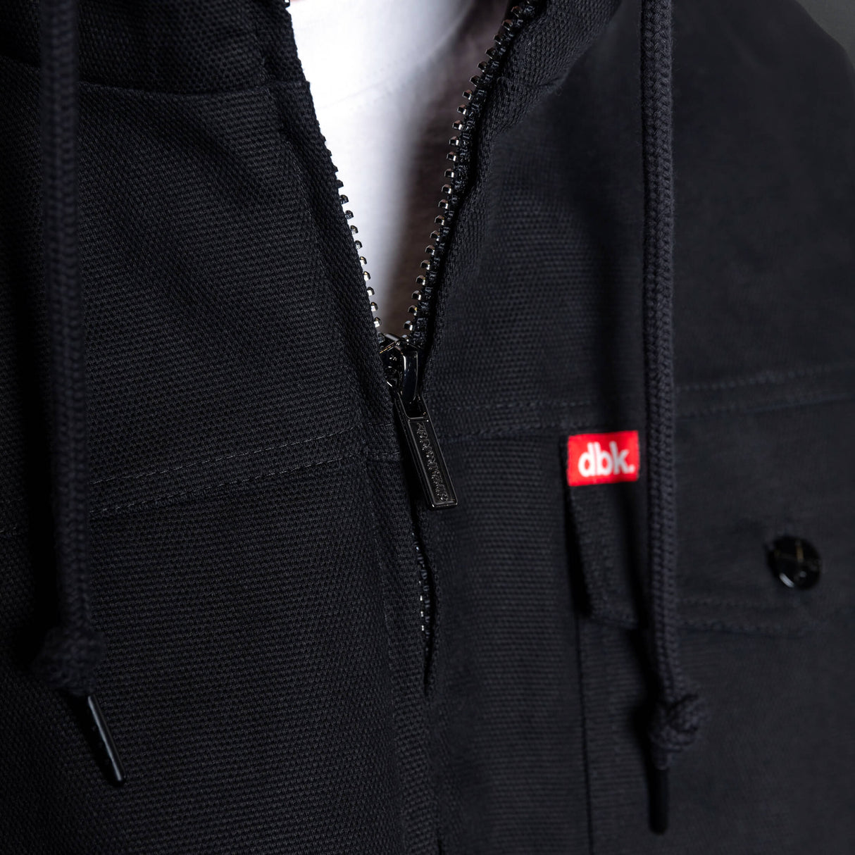 Black zip-front jacket with branded patch and contrast zipper teeth