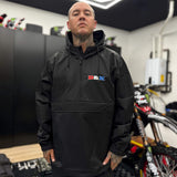 Black windbreaker with hood and small DBK logo on chest, half-zip front