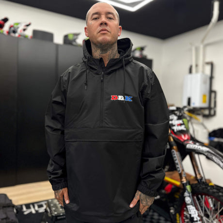 Black windbreaker with hood and small DBK logo on chest, half-zip front