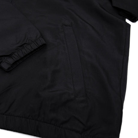 Black youth windbreaker close-up of fabric and sleeve seam with stitched paneling