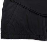 Black youth windbreaker hem close-up with elastic cuffs and visible side zipper tab