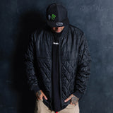 Black quilted jacket with full zipper and stand collar, worn with long sleeves