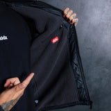 Black jacket interior lining and zipper opening, showing a branded patch label
