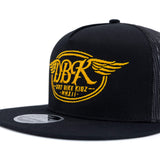 Front view of black trucker cap with yellow DBKR wing logo and text, mesh side