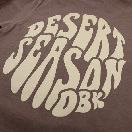 Brown womens graphic T-shirt close-up of Desert Season logo print at center