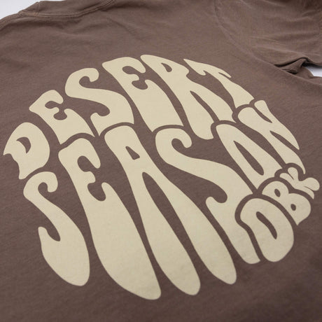 Women's brown graphic T-shirt with large cream lettering design