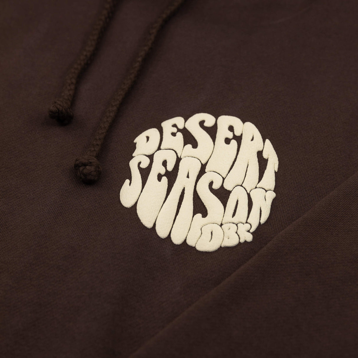 Desert Season Hoodie dunkelbraun mit weißem Logo-Print am Brustbereich