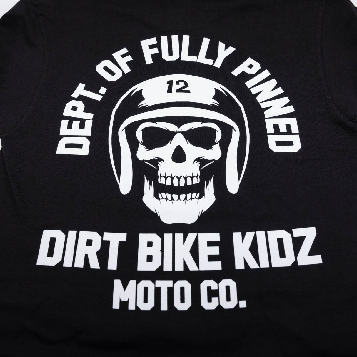 Black kids graphic tee close-up of large back skull helmet logo and “Dirt Bike Kidz.”