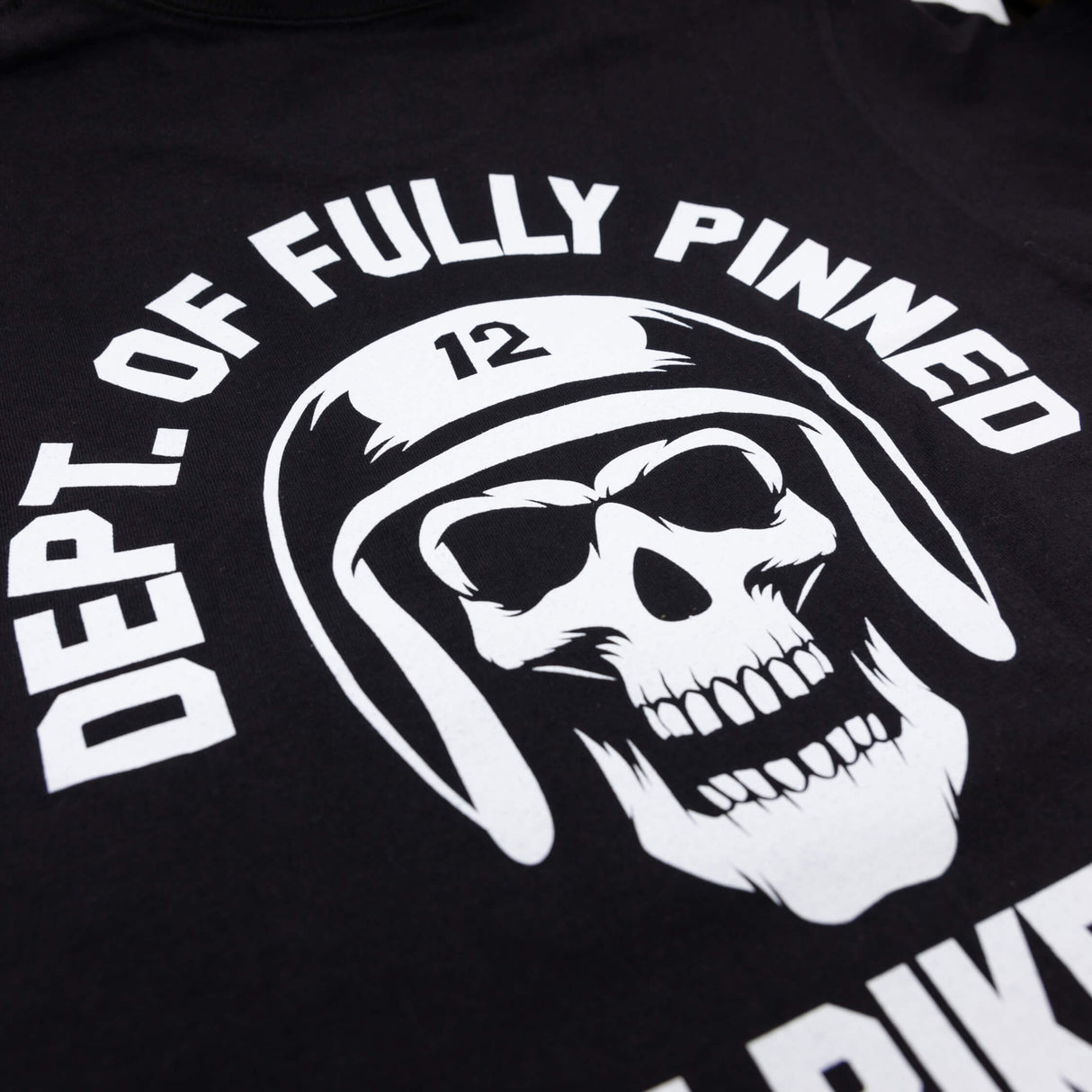 Black kids graphic tee close-up of helmet skull graphic with curved “Of Fully Pinned” text.