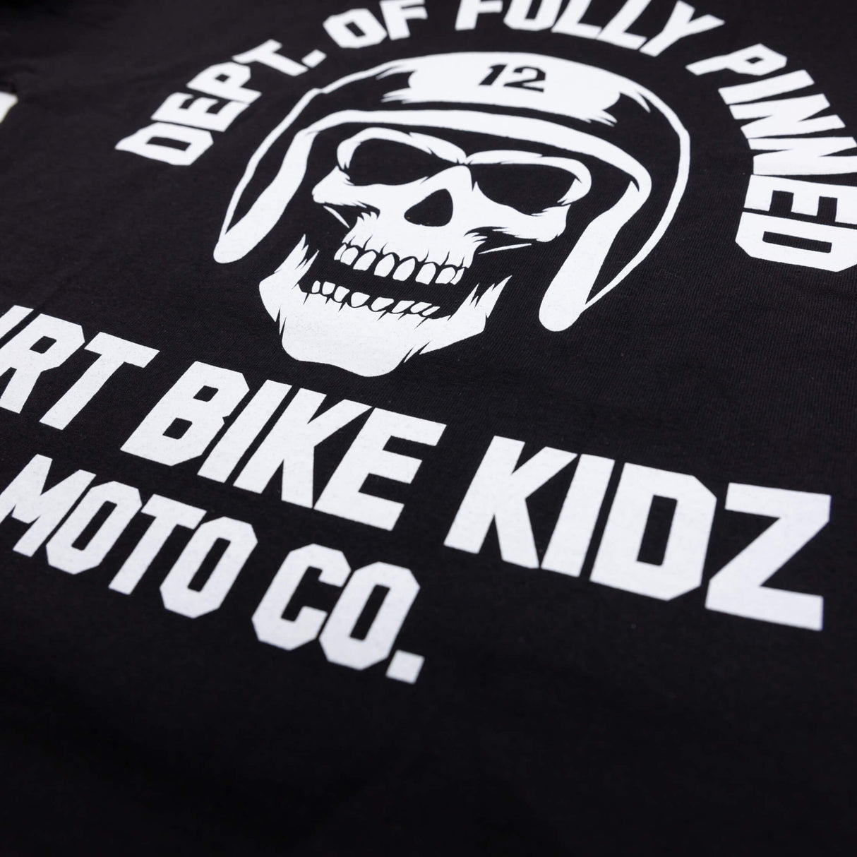 Black kids graphic tee close-up of “Dirt Bike Kidz Moto Co.” lettering and skull graphic.