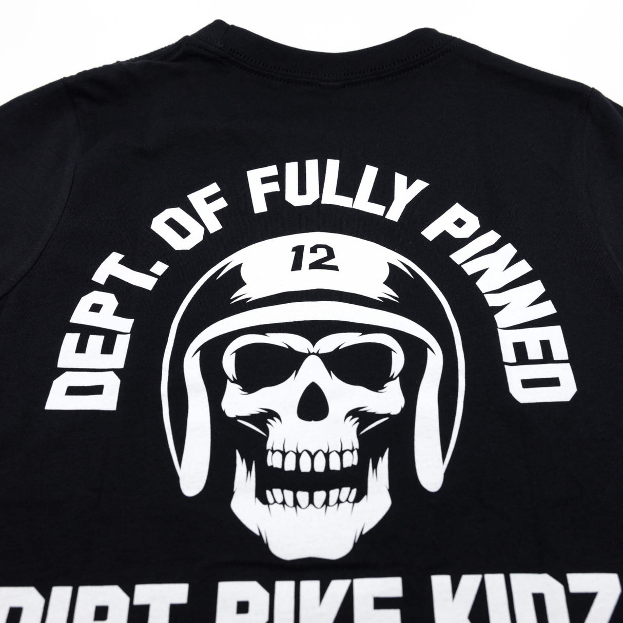 Youth premium black T-shirt back close-up: large white skull helmet graphic with arched “FULLY PINNED”