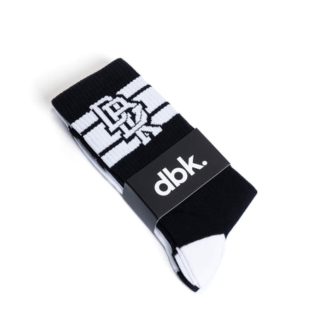 Black crew socks with white stripe cuff and “dbk.” branding on the folded label.