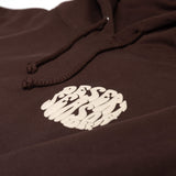 Close-up of dark brown hoodie drawstrings and small white logo on the front