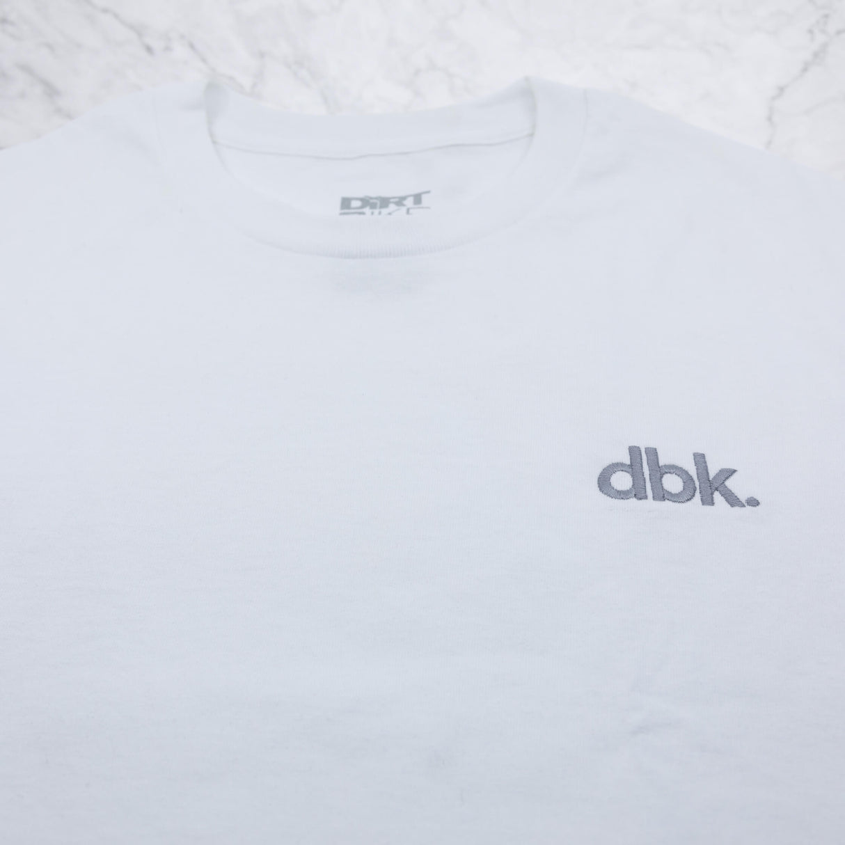 White crew T-shirt with gray dbk logo and crew neck label
