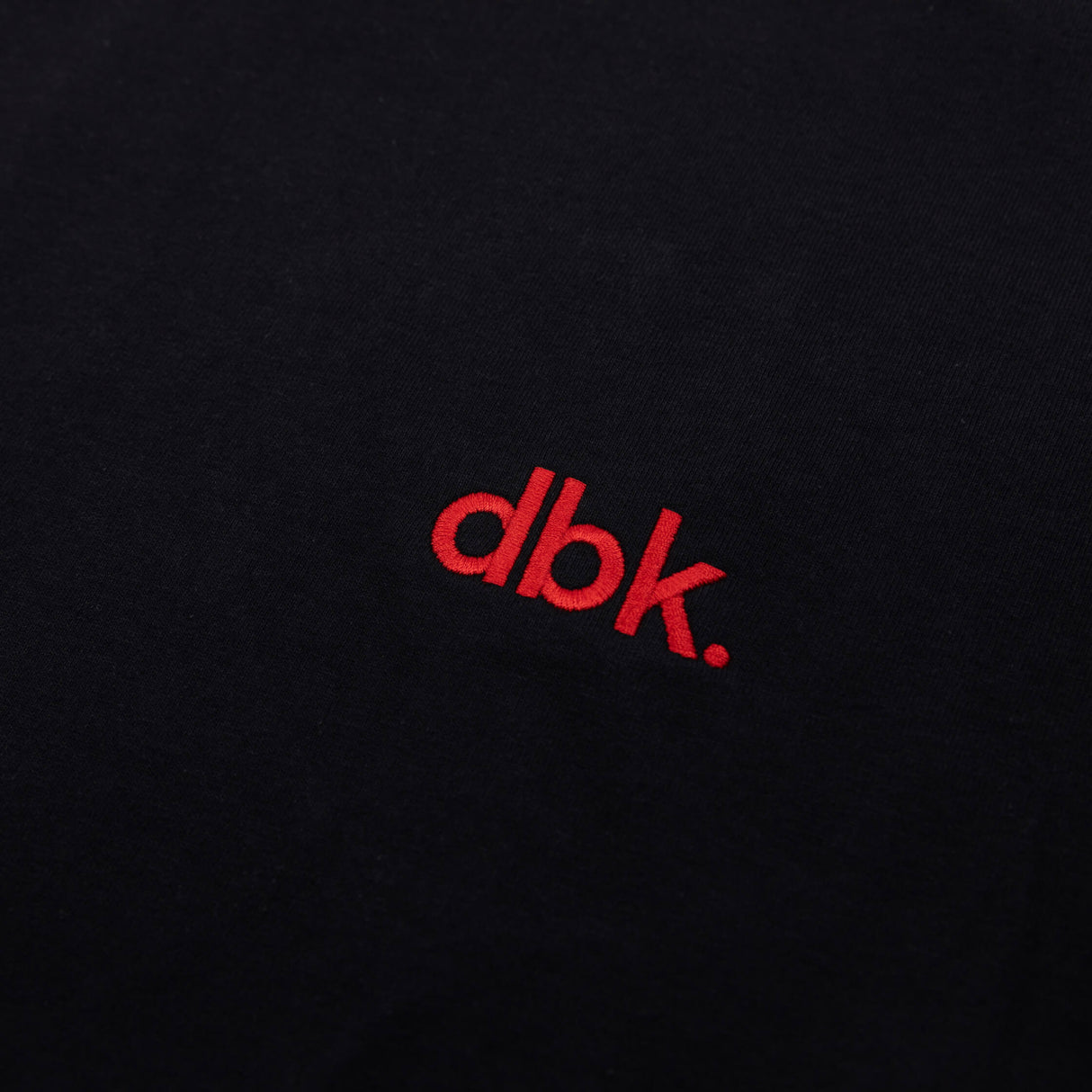 Black crew T-shirt with red dbk logo close-up