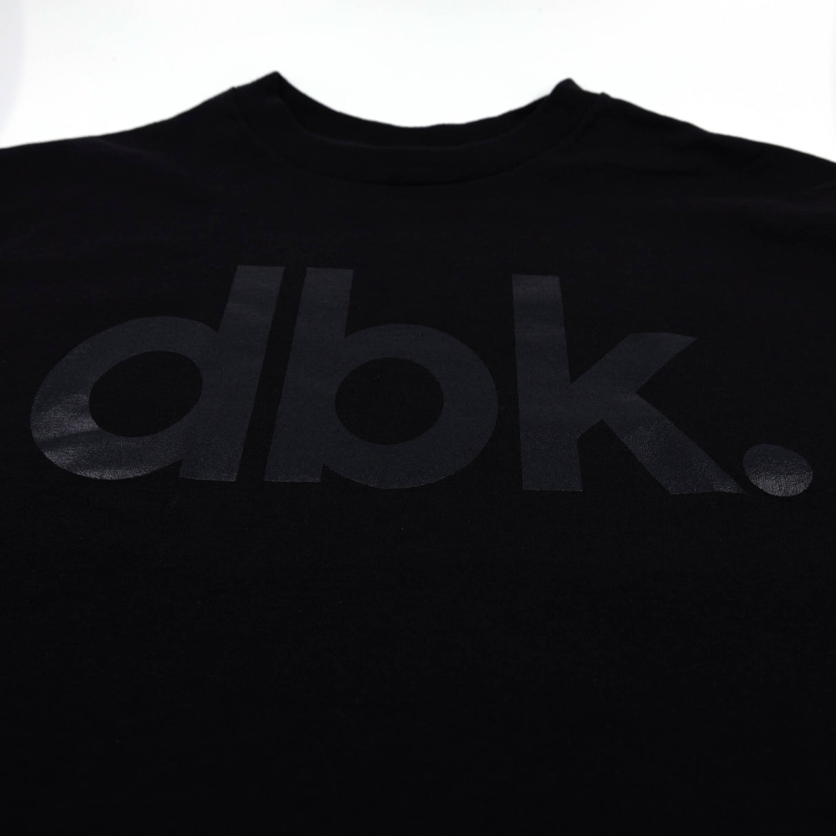Black dbk graphic T-shirt front close-up of logo