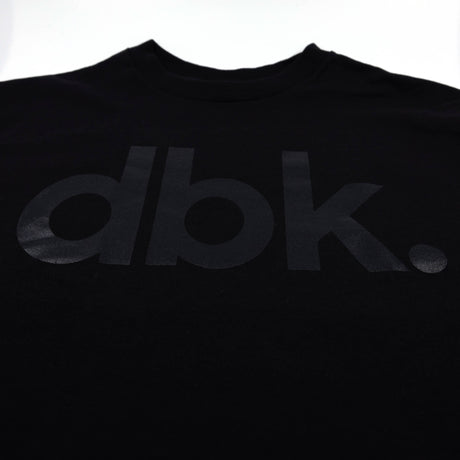 Black dbk graphic T-shirt front close-up of logo
