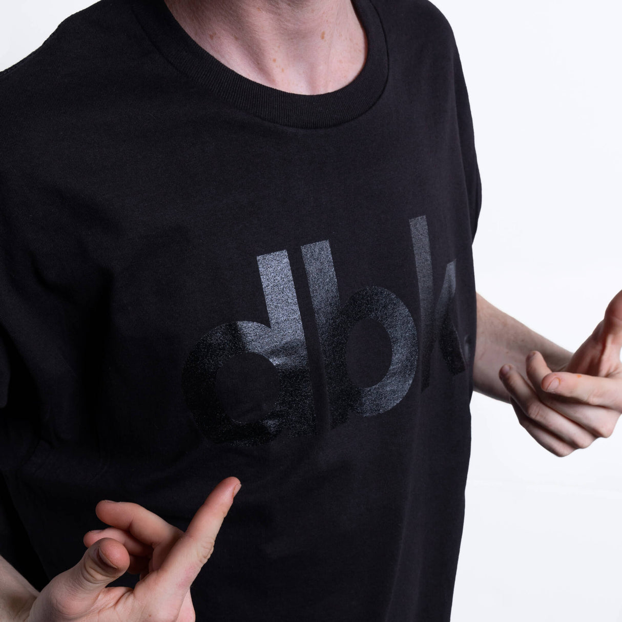 Black T-shirt close-up of dbk logo print on chest