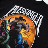 Black T-shirt close-up of Pleasinger round graphic with cowboy and crocodile