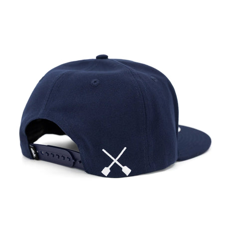 Navy snapback cap with adjustable back strap and white crossed icon