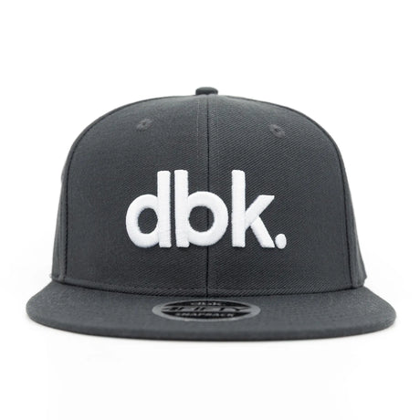 Charcoal snapback cap, front view with white "dbk" logo and circular brim patch