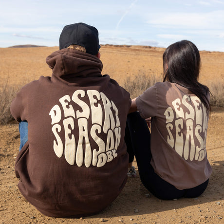 Dark brown hoodie with large back Desert Season graphic; hood up