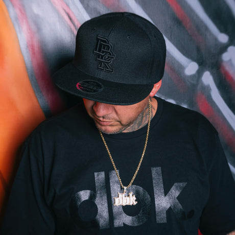 Black dbk graphic T-shirt worn by man looking down