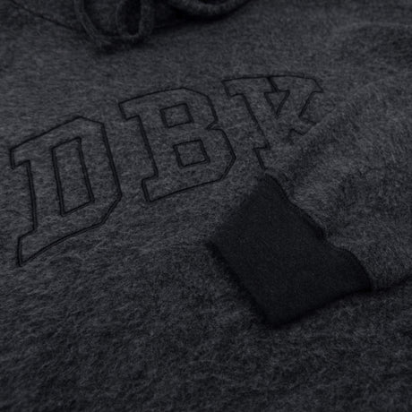 Women’s dark charcoal pullover hoodie close-up of front logo embroidery and fabric texture
