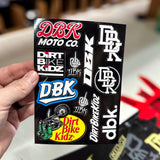 DBK Moto Co sticker pack held in hand, with Dirt Bike Kidz and DBK logo graphics