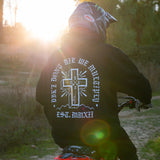 Black zip hoodie with back cross emblem graphic and hood, worn outdoors.