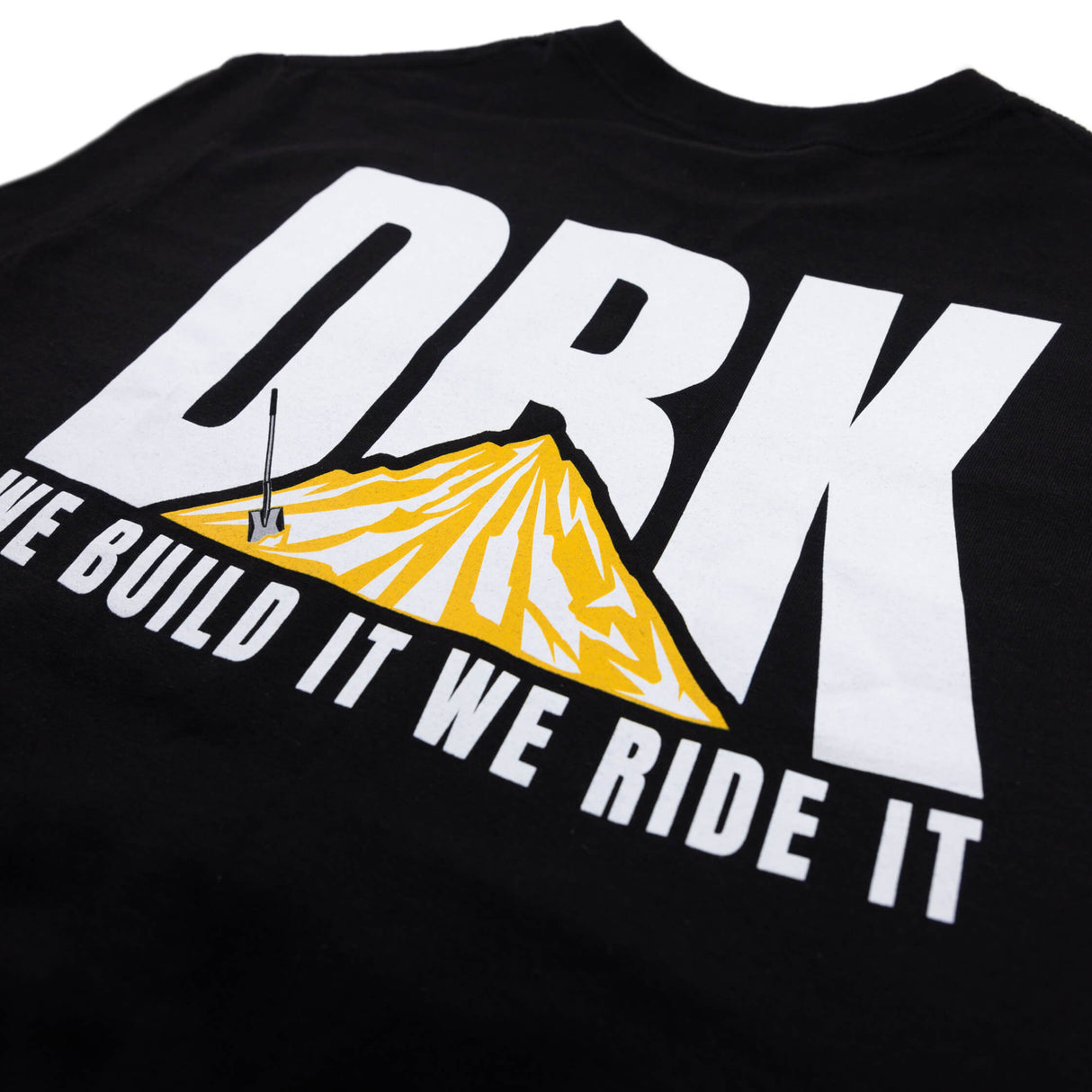 Black crewneck T-shirt close-up of diagonal 'WE BUILD IT WE RIDE IT' over DRK