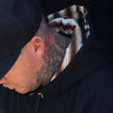 Black hoodie with striped hood lining and gold-tipped drawstring cords at the neckline.