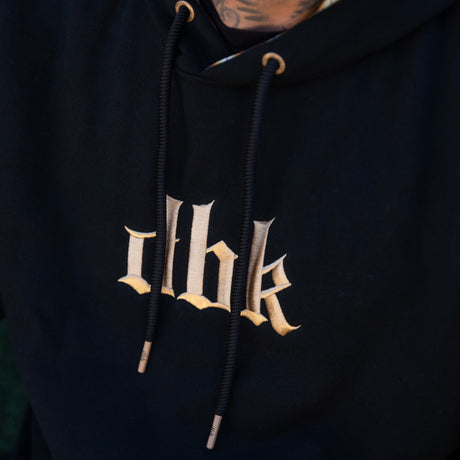 Premium hoodie in dark black with beige chest graphic and drawstring hood