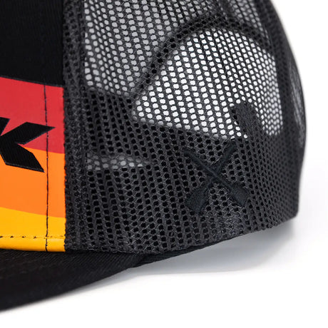 Close-up of black mesh trucker cap side panel with orange-red logo stripe