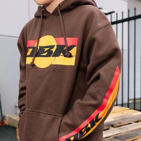 Dark brown hoodie with front DBK logo, red-yellow sleeve stripes, and drawstring hood
