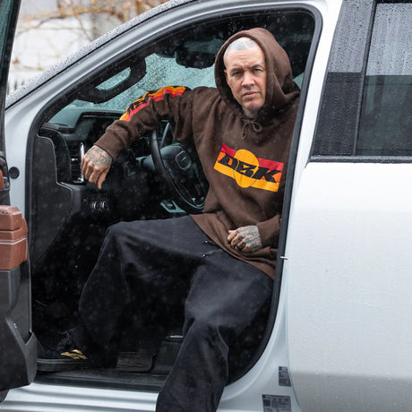 Dark brown hoodie with DBK logo graphic on the back and red-yellow sleeve stripes