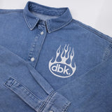 Burnout oversized denim shirt close-up: buttoned placket and large flame dbk chest logo