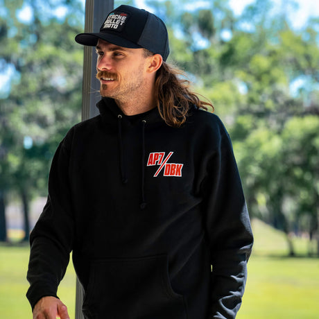 Black trucker cap with Stache Mullet Moto front patch, worn on head