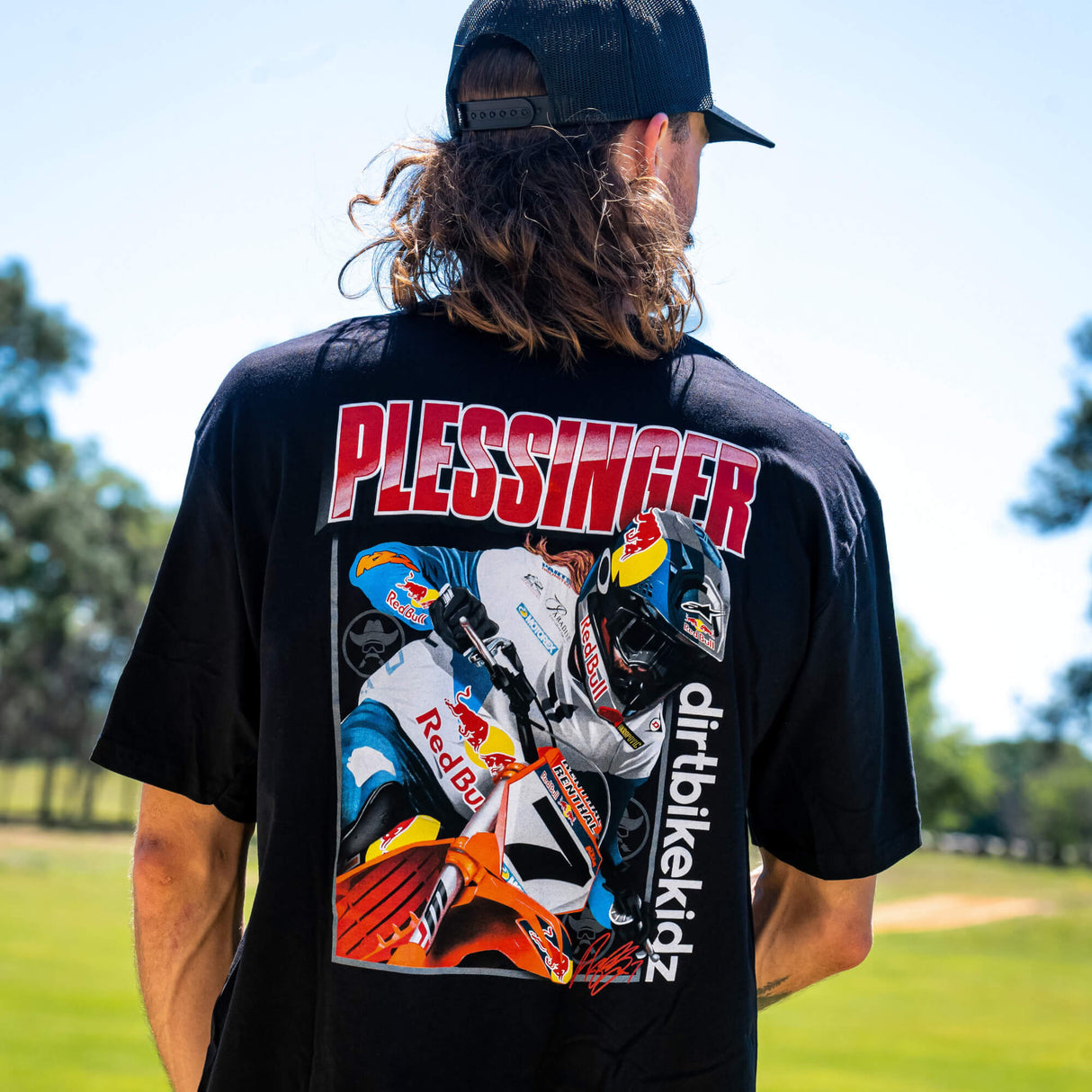 Black AP7 tee worn outdoors with large PLESSINGFER back graphic