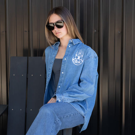 Burnout oversized denim shirt on model, light blue with flame dbk logo and button sleeves