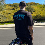 Black T-shirt, back view, with blue DBK logo graphic centered.