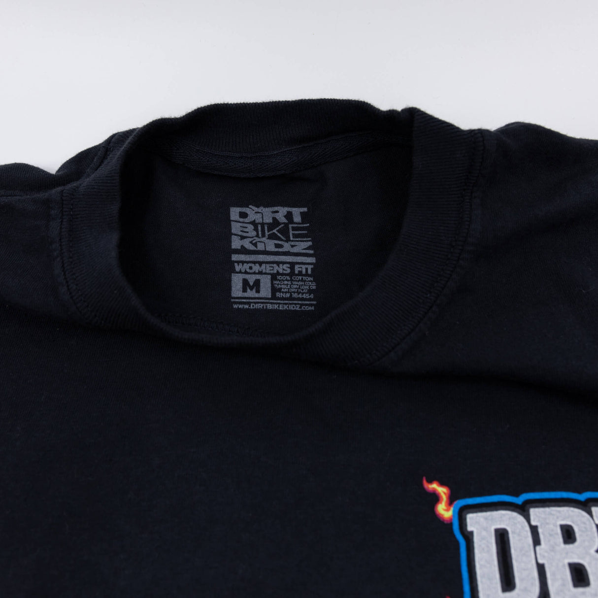 Women's black T-shirt collar with size label and partial DBK logo