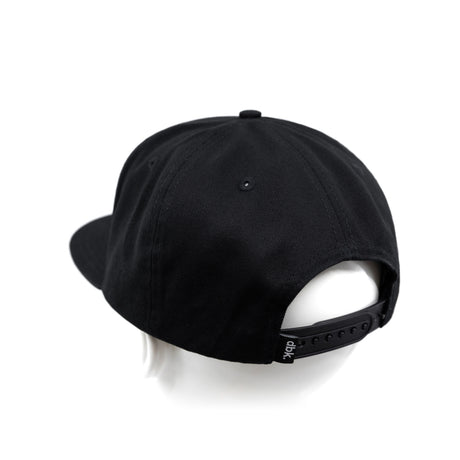 Black snapback cap with adjustable back strap showing dbk branding.