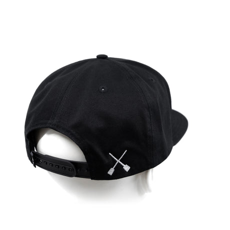 Black snapback cap with white X logo on side and curved brim