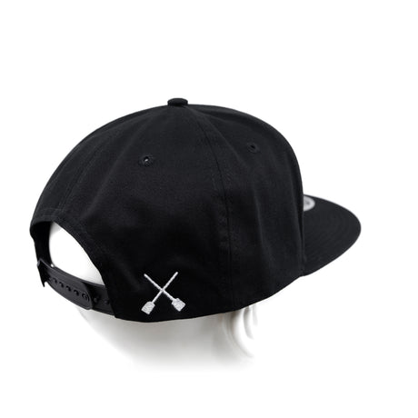 Black snapback cap with X logo near side panel and adjustable back strap
