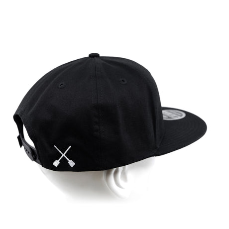 Black snapback cap with X logo on front side and adjustable back strap